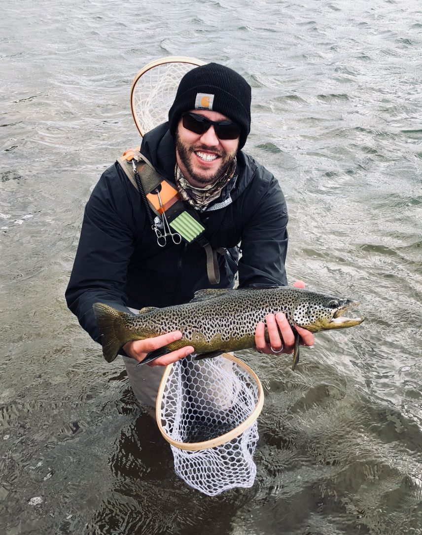 employee holding a fish while going fishing