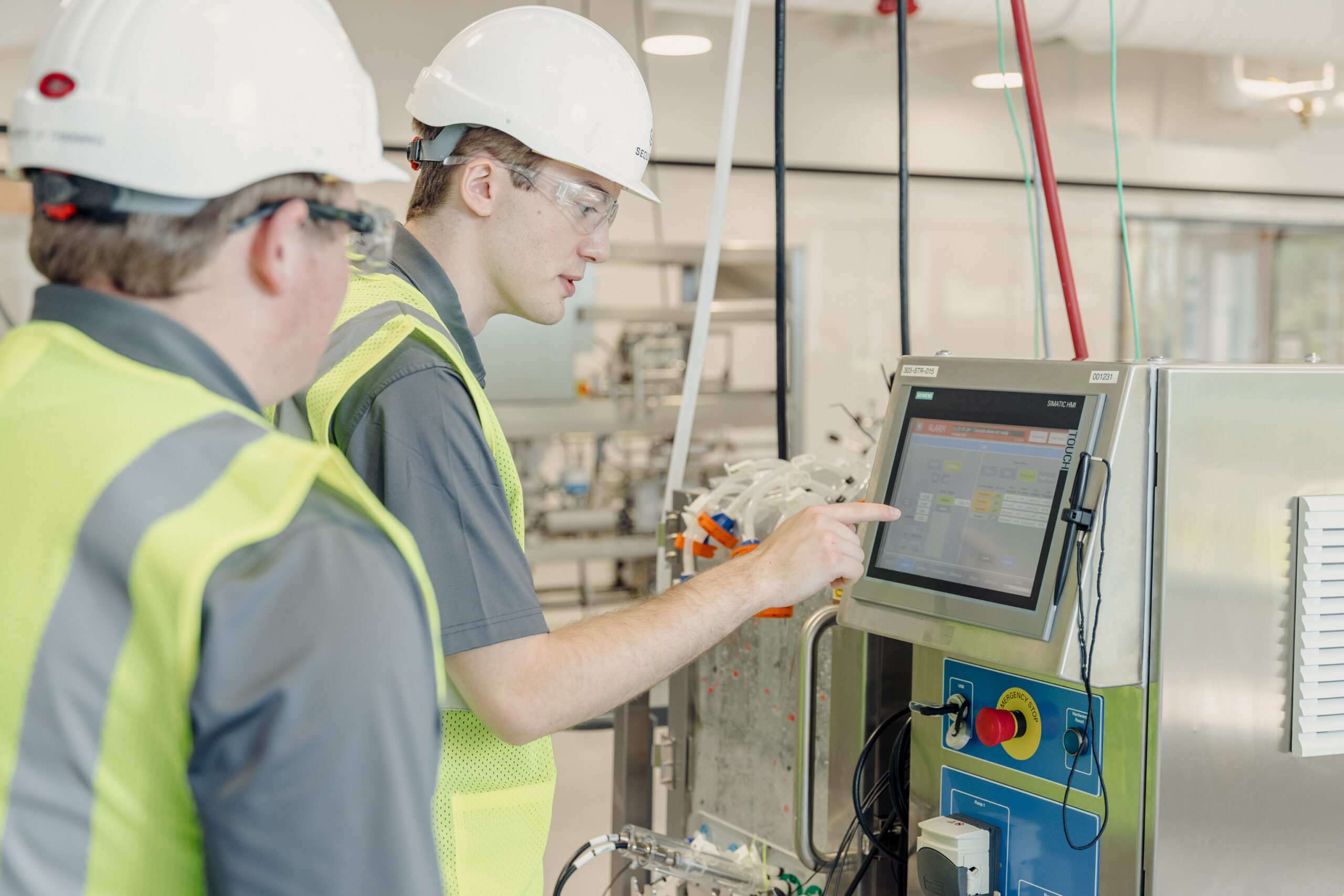 Sequence engineering consultants performing technical documentation review and process engineering analysis at a pharmaceutical manufacturing facility